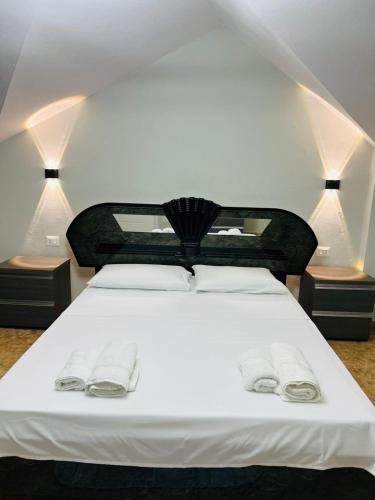a bedroom with a white bed with two towels on it at Potka Apartments Tirane in Yzberishti