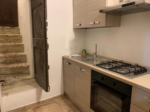 eine Küche mit Herd oberer Ofen neben einer Spüle in der Unterkunft Monte Cavallo in Assisi