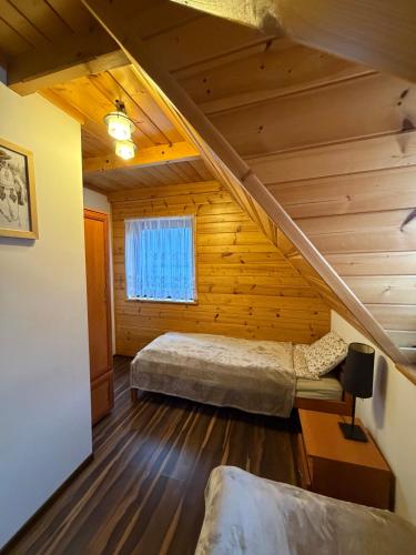 a attic room with a bed and a window at Noclegi u Gubały in Szaflary