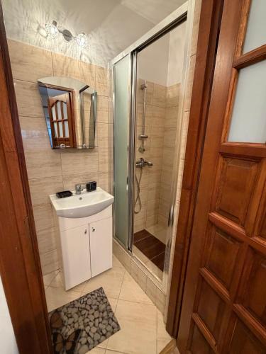 a bathroom with a sink and a shower and a mirror at Noclegi u Gubały in Szaflary