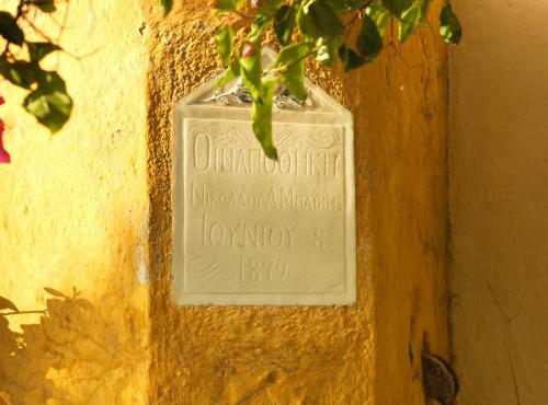 a sign on the side of a wall at AFOURA HOUSES by K&K in Pyrgos