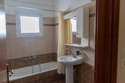 a bathroom with a sink and a bath tub at Philoxenia Studio Larissa in Larisa