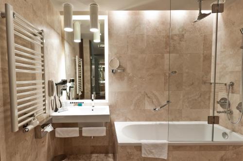 Golden Tulip Ana Dome Hotel في كلوي نابوكا: حمام مع حوض ومغسلة ودش