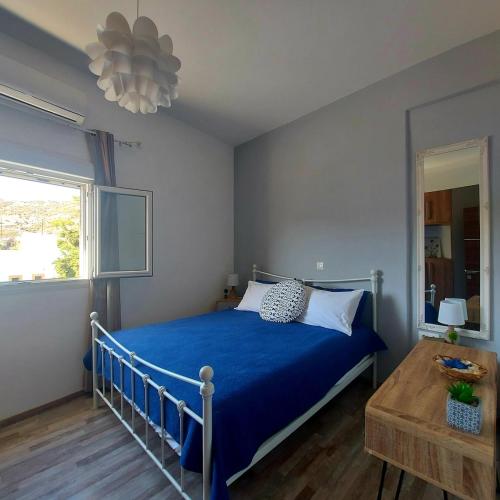 a bedroom with a blue bed and a window at Calliope #1 in Skala