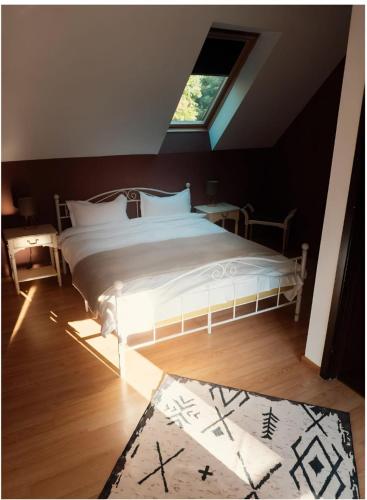 a bedroom with a large white bed with a window at Transylvanian Nest in Cristian