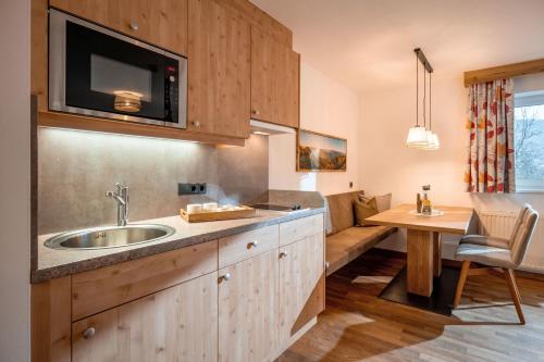 a kitchen with a sink and a microwave above it at Appartementhaus Fuchs in Itter