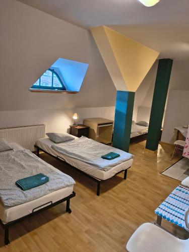 a room with two beds and a ceiling with a window at U Szermierzy in Wrocław