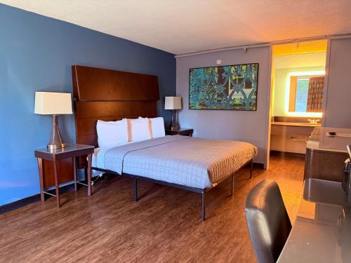 a bedroom with a bed and a blue wall at Heritage Inn Cartersville in Cartersville