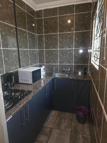 una cucina con forno a microonde e lavandino di The Good Samaritan 3 a Witbank