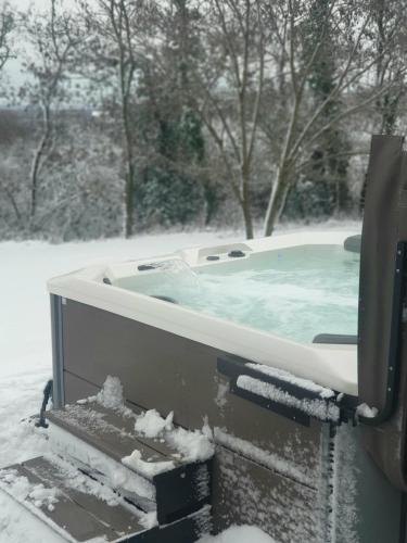 a jacuzzi tub covered in snow in a yard at Hilltop House. in Erdut