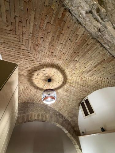 a ceiling in a room with a stone wall at Vicolo San rufino in Assisi
