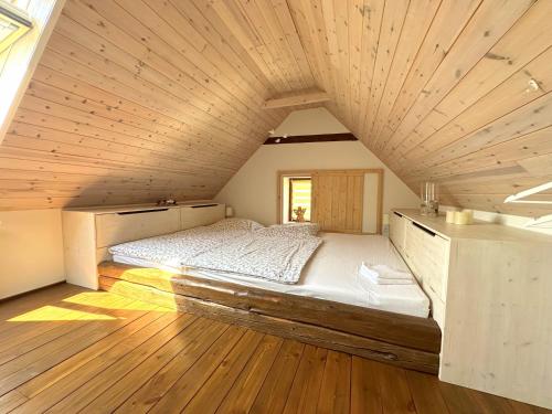 a large bed in a room with a wooden ceiling at Chalupa Za Vraty Jevišovice in Jevišovice
