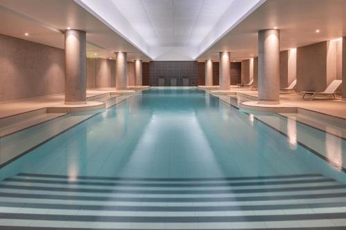 a swimming pool with blue water in a building at Radisson Blu CDG Airport Terminal Hotel, Paris in Tremblay-En-France