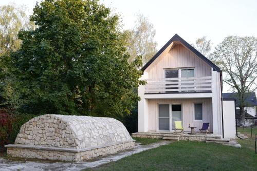 a small house with a large stone wall in front of it at Chata z Kraja in Józefów