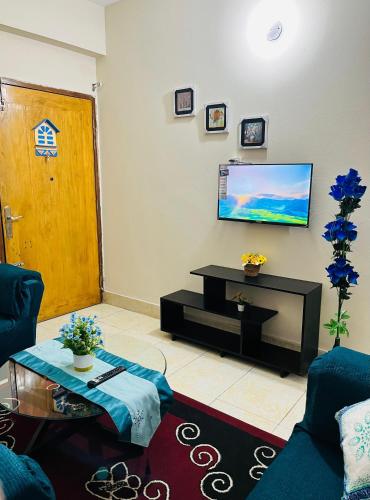 un soggiorno con un divano e una televisione di Paradise Suite's a Dhaka