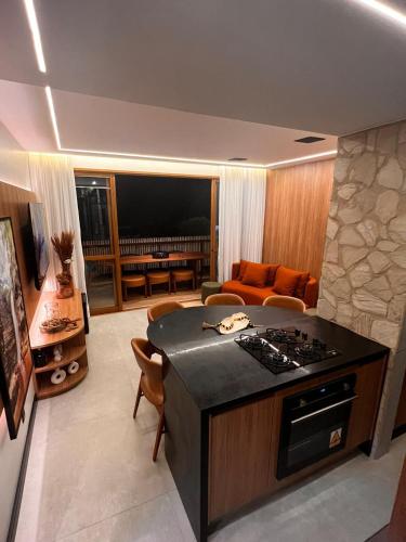 a kitchen with a stove and a living room with a couch at Mucugê- Charm Village in Mucugê