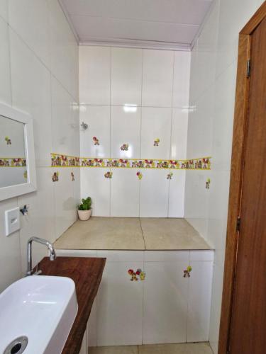 a bathroom with white cabinets and a sink at Encantos do vale Teresópolis in Teresópolis