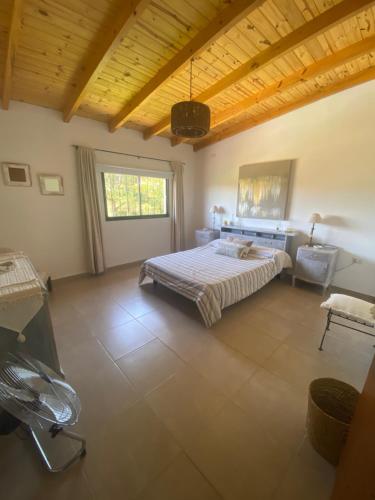 a bedroom with a bed and a chair in it at TANTI casa con pileta in Cordoba