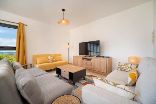 a living room with a couch and a tv at Laena Lodge in Papeete