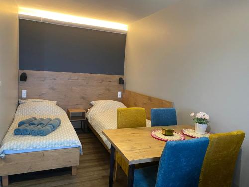 a dining room with two beds and a table and chairs at Apartament Ksawery parking w cenie podgrzewany basen in Rewal