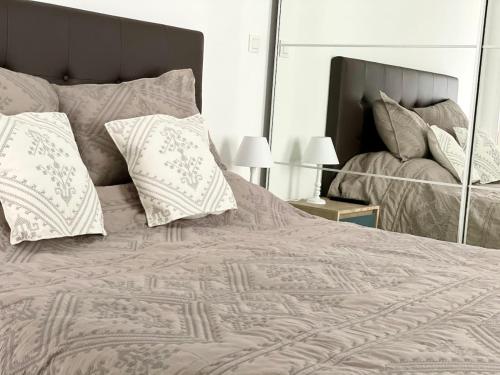 a bedroom with a large bed with pillows and a mirror at Cannes Maria in Cannes
