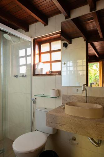 a bathroom with a toilet and a sink and a shower at Pousada Ypê das Montanhas in Monte Alegre do Sul