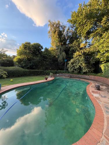a swimming pool in a yard with a brick border at Moya Guesthouse in Johannesburg