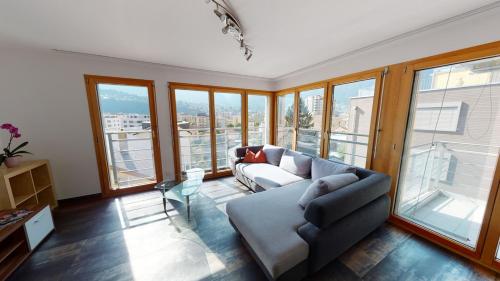 a living room with a couch and some windows at Bijou in Mitten von Naters in Naters