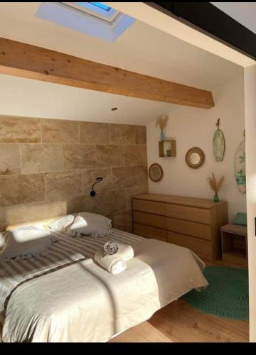 a bedroom with a bed with towels on it at O'sun avec jacuzzi privatif in Frontignan