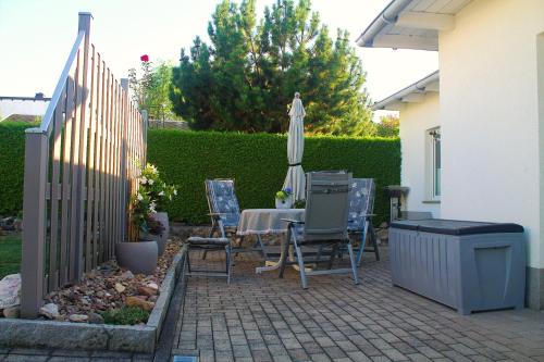a patio with a table and an umbrella and chairs at Ferienwohnung Borken in Bad Salzungen
