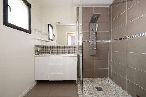 a bathroom with a shower and a sink and a mirror at Maison Épure - maison mitoyenne avec jardin in Colomiers
