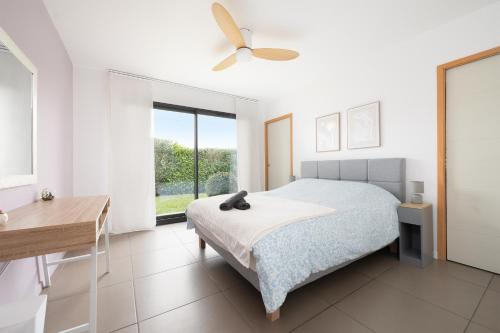 a bedroom with a bed and a ceiling fan at Maison Épure - maison mitoyenne avec jardin in Colomiers
