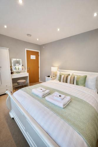 a bedroom with a large white bed with towels on it at Lady Peckett's Yard in York