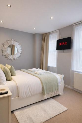 a bedroom with a white bed and a mirror at Lady Peckett's Yard in York