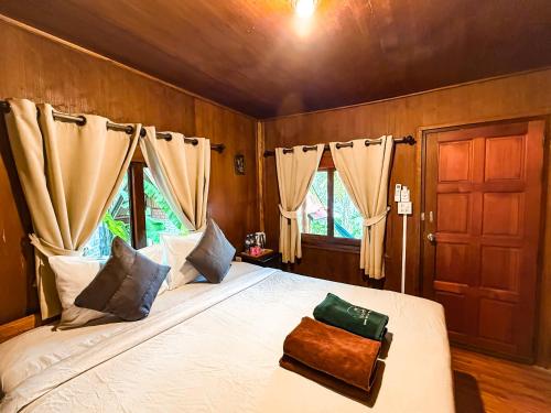 a bedroom with a large bed with a wooden wall at Bounty Resort in Haad Son