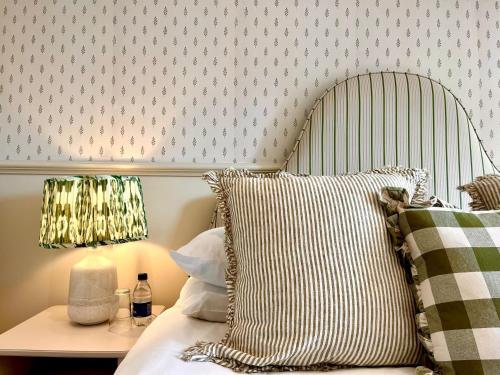 een bed met een hoofdeinde en een tafel met een lamp bij The Fox Inn in Ansty