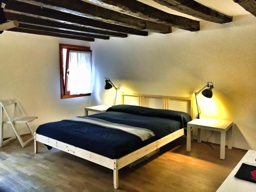 1 dormitorio con 1 cama, 2 mesas y una ventana en Al pozzo Apartment, en Venecia