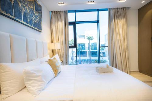 a bedroom with a white bed with a large window at Danah Bay Beachside Private Villa in Ras al Khaimah