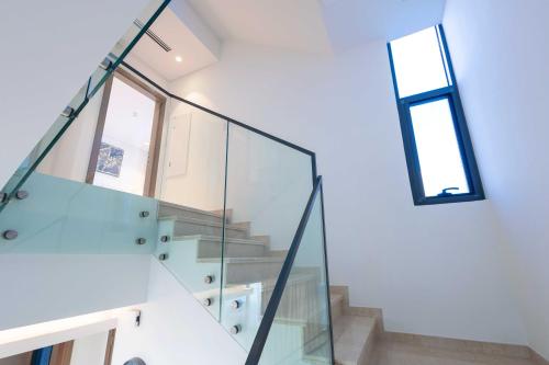 a glass staircase in a house with a window at Danah Bay Beachside Private Villa in Ras al Khaimah
