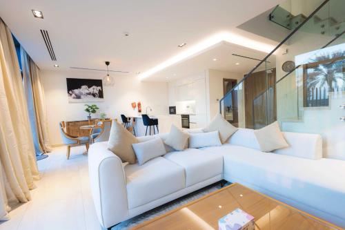 a living room with a white couch and a table at Danah Bay Beachside Private Villa in Ras al Khaimah