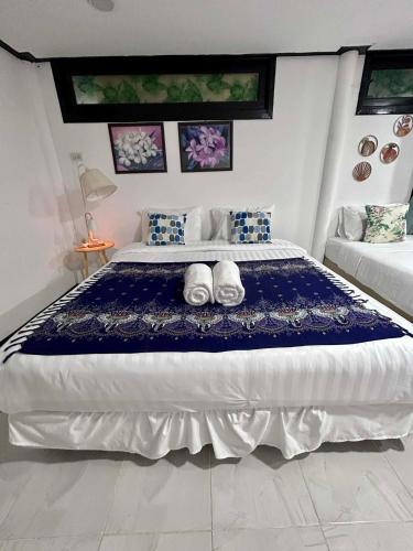 a bedroom with a large bed with a blue blanket at Hayar House's Cabin house at kantiang bay in Ko Lanta