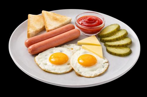 Een bord met ontbijtproducten zoals eieren, kaas en augurken. bij Avto Spa in Chmelnytsky