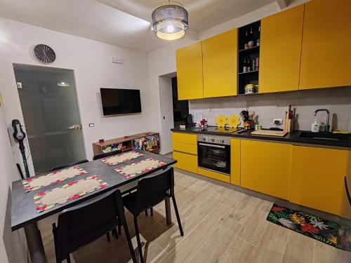 una cucina con mobili gialli e un tavolo con sedie di Appartamento alla Immacolata Noto Centro Storico a Noto