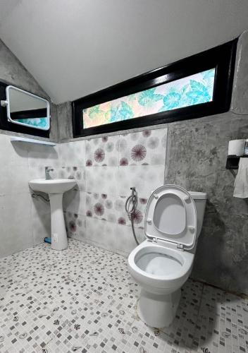 a bathroom with a toilet and a sink and a window at Hayar House's Cabin house at kantiang bay in Ko Lanta