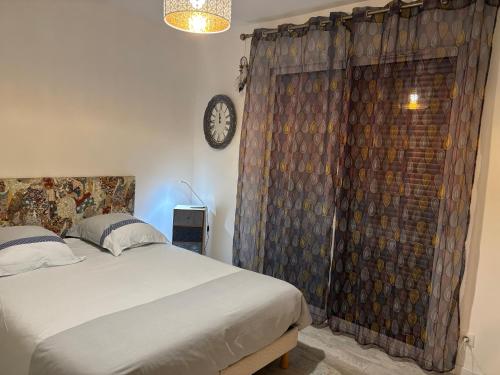 een slaapkamer met een bed en een klok aan de muur bij La perle in Les Mathes