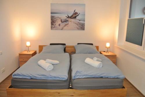two twin beds in a room with two lamps at Ferienwohnung Meer-Zeit in Lubmin