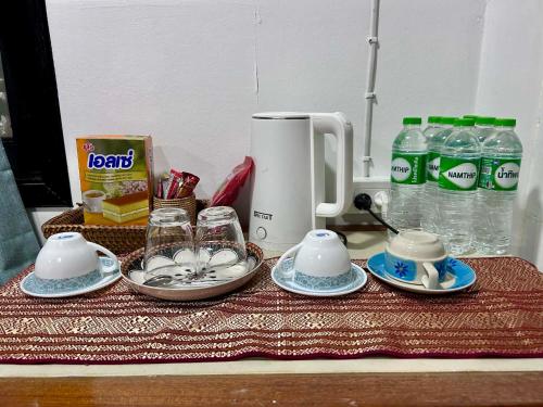 a table topped with cups and dishes and water bottles at Hayar House's Cabin house at kantiang bay in Ko Lanta