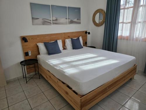 a bedroom with a large bed with blue pillows at Serenity Dominicus in La Laguna