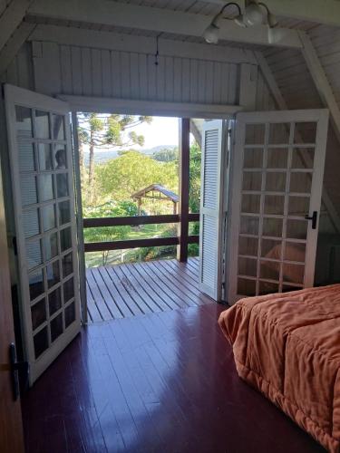 an open door to a room with a bed and a balcony at Cabana da Serra in Riozinho