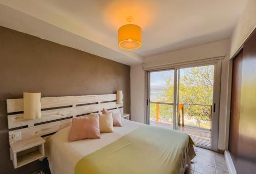 a bedroom with a bed and a large window at PUEBLO CHICO - casas de lago in Villa Ciudad de América